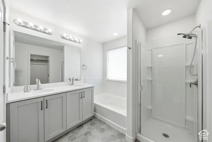 Bathroom with dual vanity featuring light gray cabinetry and white countertops