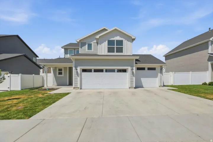 Two-story residence featuring light gray siding and white trim