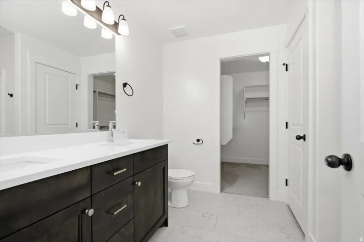 Dual-sink vanity with a dark wood-finish cabinet and white countertop