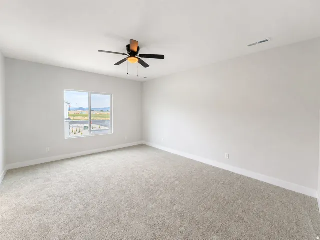 Spacious room featuring neutral carpeting and white baseboards