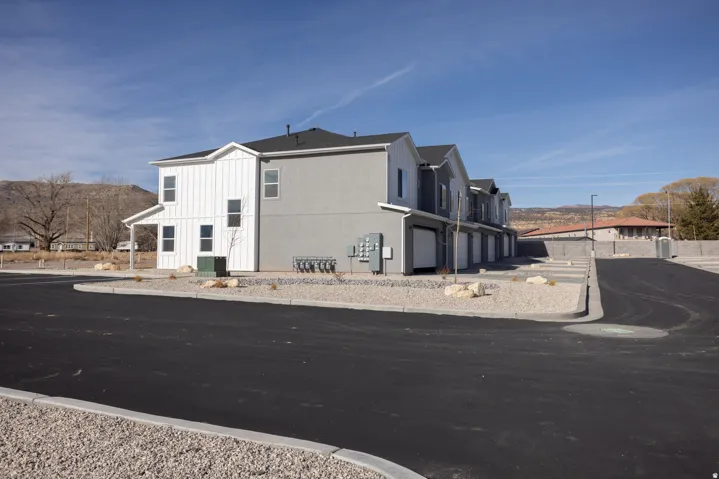 Modern multi-unit property featuring vertical white siding and gray stucco exteriors