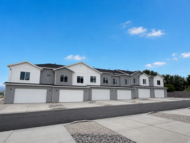Contemporary multi-unit property with a combination of light and dark gray stucco siding and white board-and-batten accents