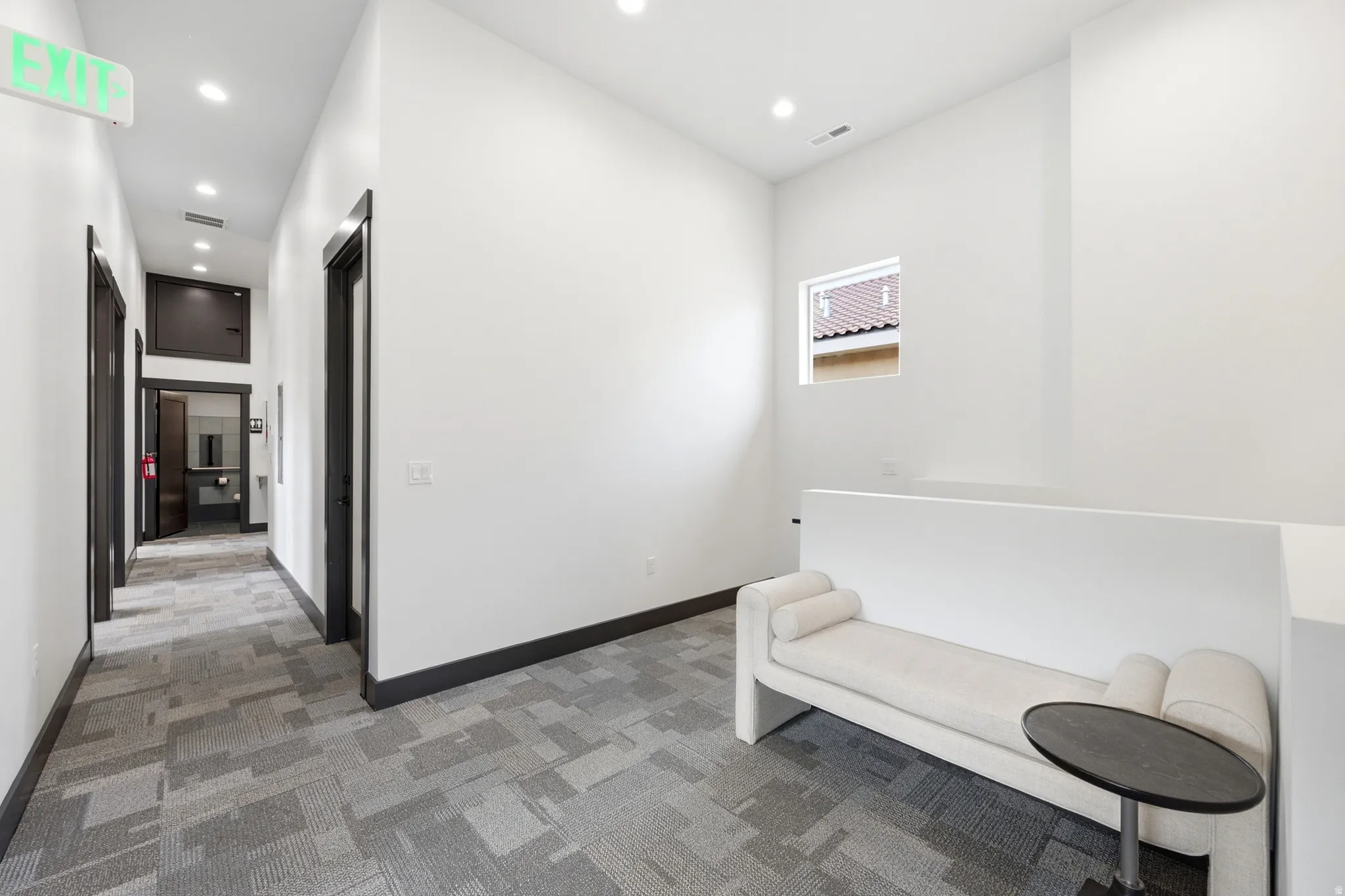 Hallway with recessed lighting, dark trim, and a patterned carpet
