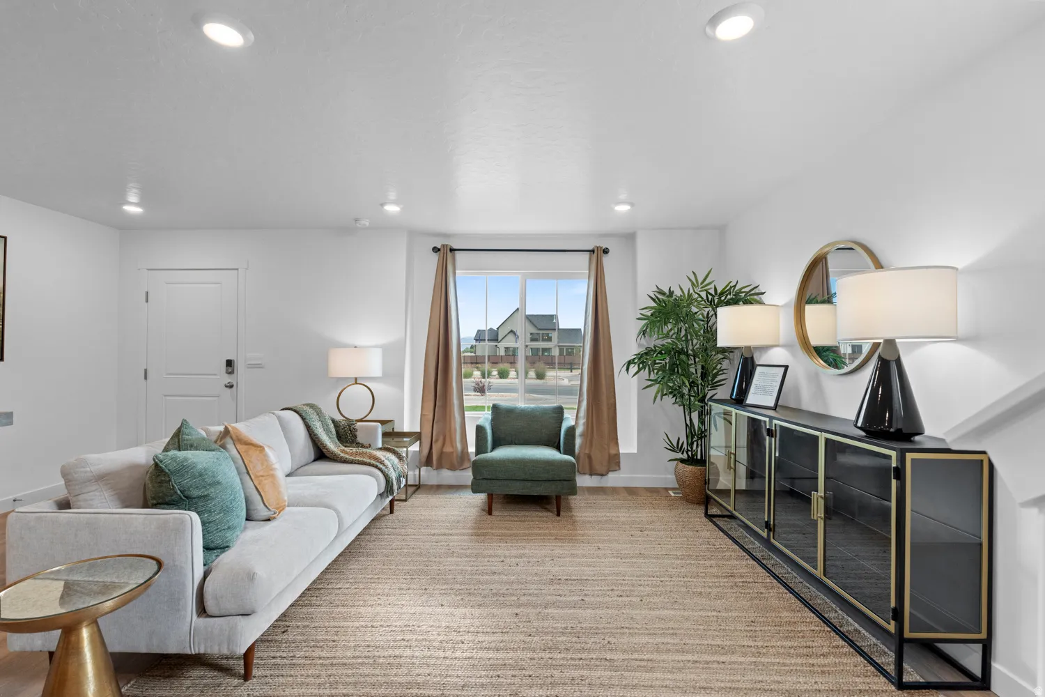 Bright living area featuring recessed lighting, a large window with neutral drapery, and a textured area rug