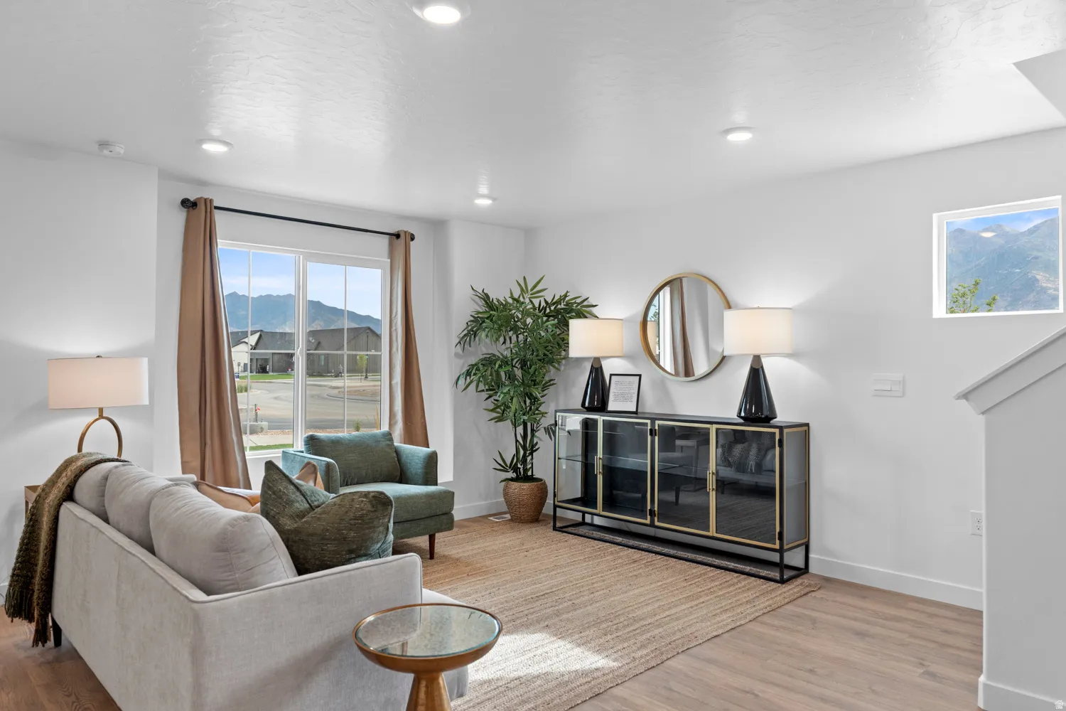 Spacious living area featuring expansive windows with mountain scenery, recessed lighting, and wood-finish flooring