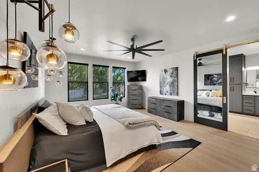 Bright interior space featuring wood-finish flooring and a contemporary black ceiling fan