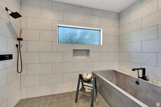 Contemporary bathroom featuring a modern soaking tub with matte black fixtures, a rain showerhead, and a wall-mounted handheld shower