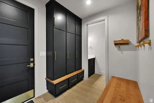 Entryway featuring a built-in black cabinetry system with gold-tone hardware, integrated seating, and storage drawers