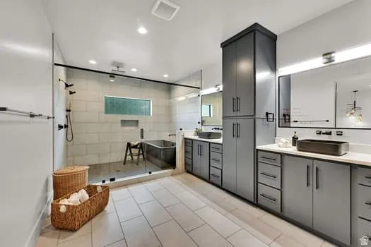 Spacious bathroom featuring a glass-enclosed shower with a built-in bench and a deep soaking tub