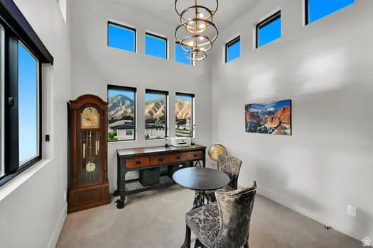 Interior space with high ceilings and multiple windows showcasing mountainous terrain