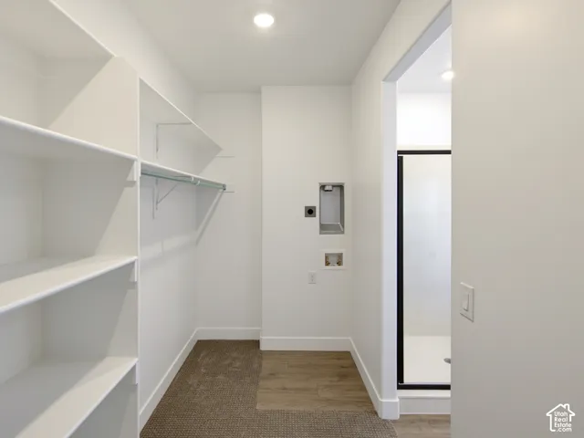 Utility room featuring built-in white shelving, recessed lighting, and dedicated washer and dryer hookups
