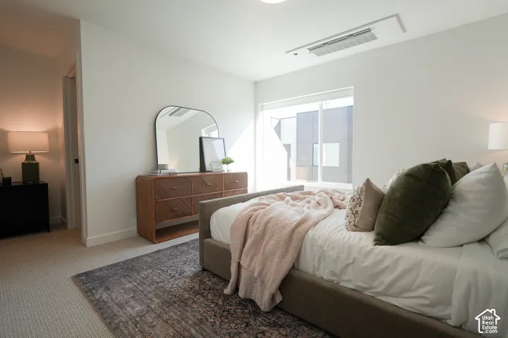 Neutral interior featuring wall-to-wall carpeting, recessed ceiling-mounted climate control unit, and oversized window with white trim