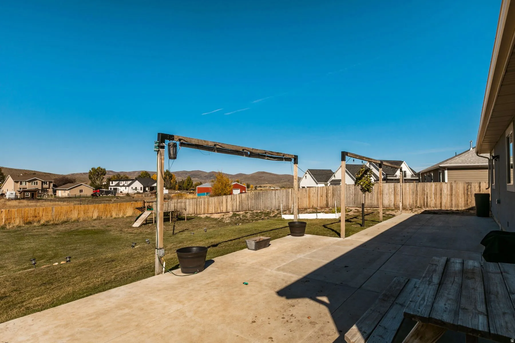 Spacious concrete patio with exposed aggregate finish and a wood privacy fence