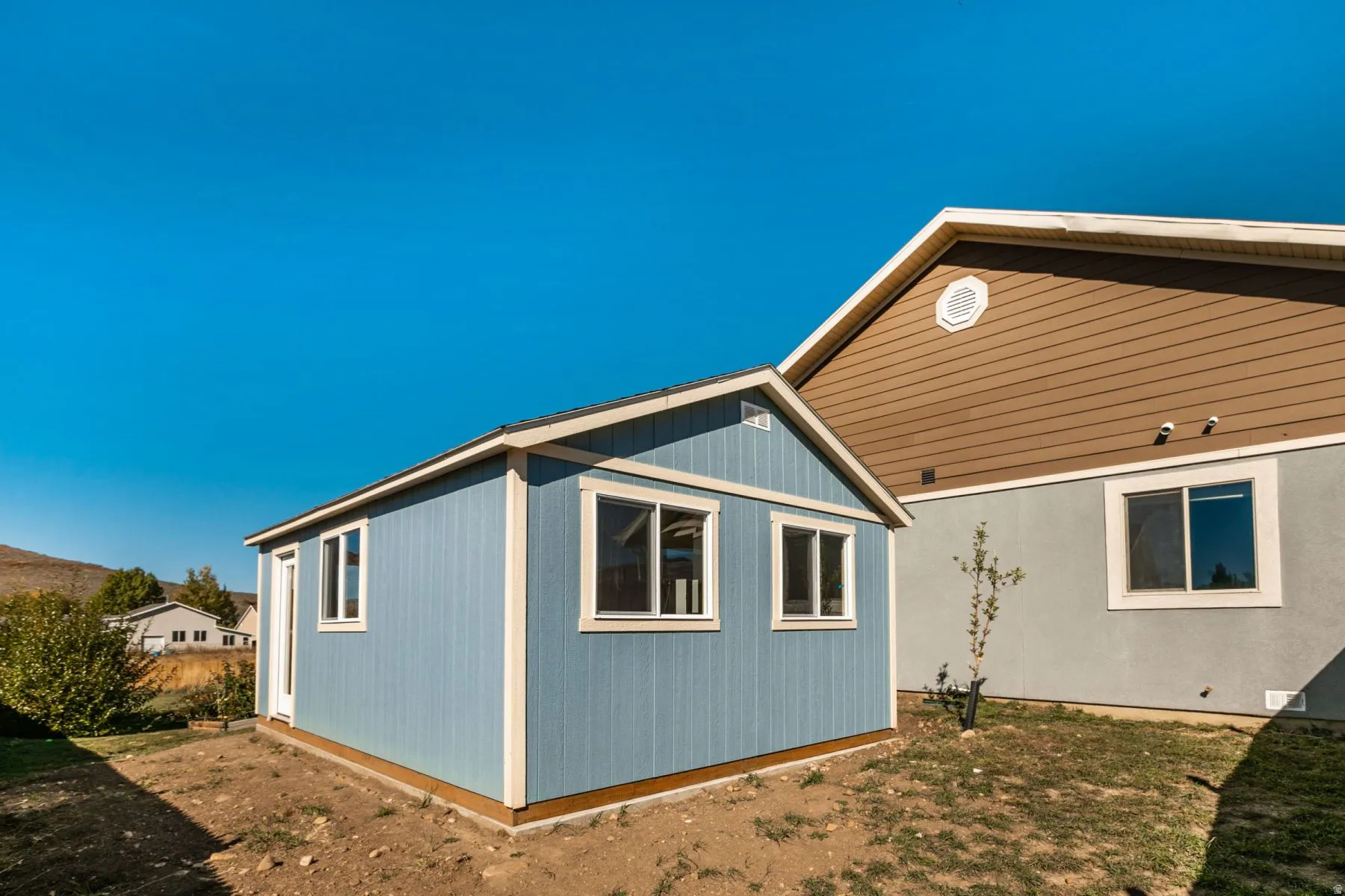 Detached outbuilding with blue siding and white trim