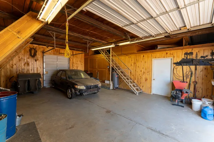 Concrete flooring with wood-paneled walls and a metal roll-up door