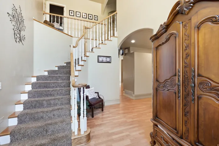 Curved staircase with wood-finish handrail and carpeted treads