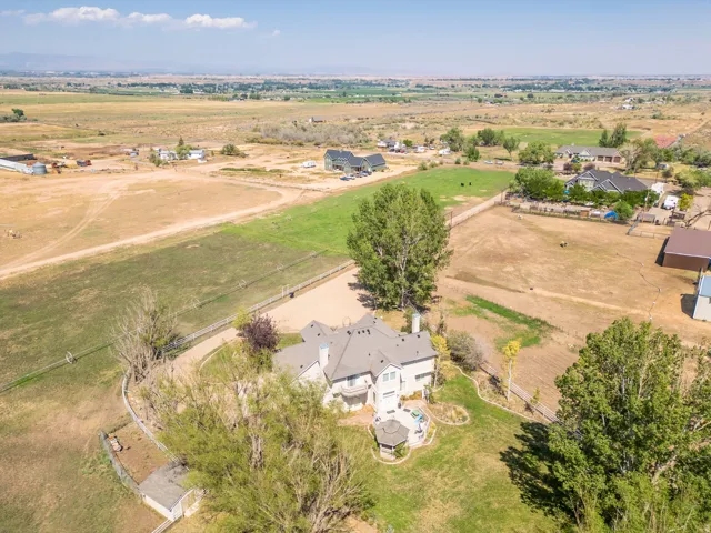 Expansive property with a large main residence, multiple outbuildings, and a surrounding agricultural landscape