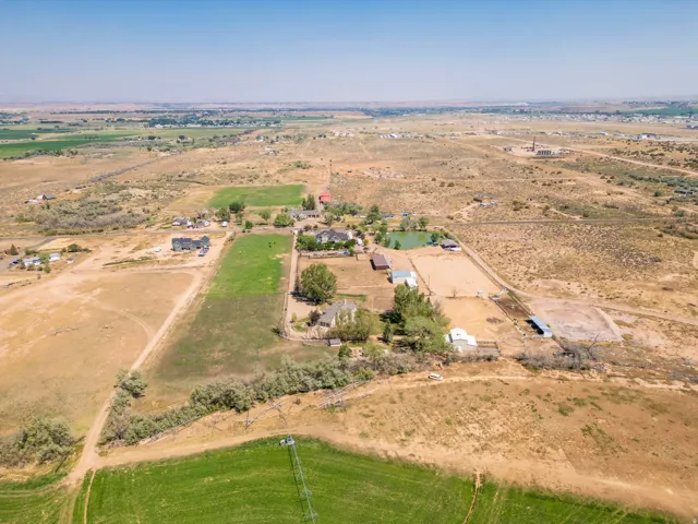 Expansive property featuring multiple structures, a pond, and open land