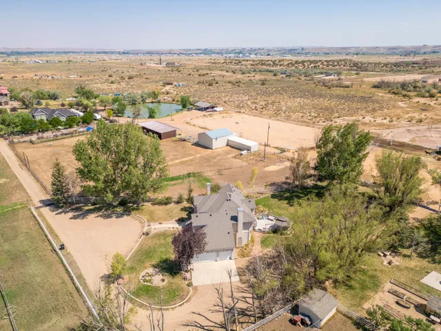 Extensive grounds featuring a detached outbuilding, multiple accessory structures, and a private pond