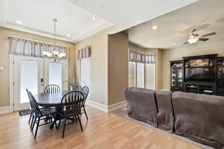 Hardwood-style flooring with a tray ceiling and recessed lighting