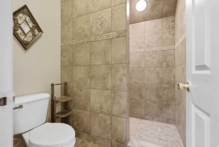 Walk-in shower with full-height tile surround, mosaic tile accents, and recessed lighting