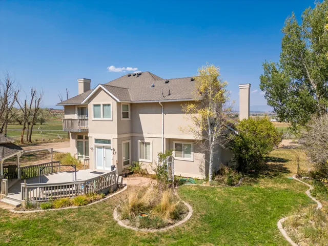 Exterior featuring a stucco finish, a private balcony, a ground-level deck, and a multi-level roofline