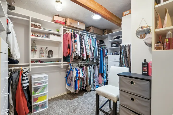Custom closet system with multiple shelving units, hanging rods, built-in drawers, and overhead storage