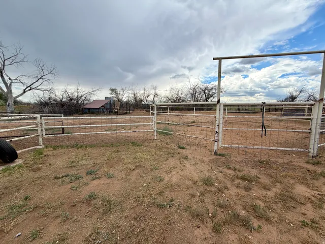 Fenced outdoor enclosure with metal panels and gate