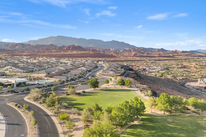 Expansive community with varied architectural styles, a large green space, and a community pool