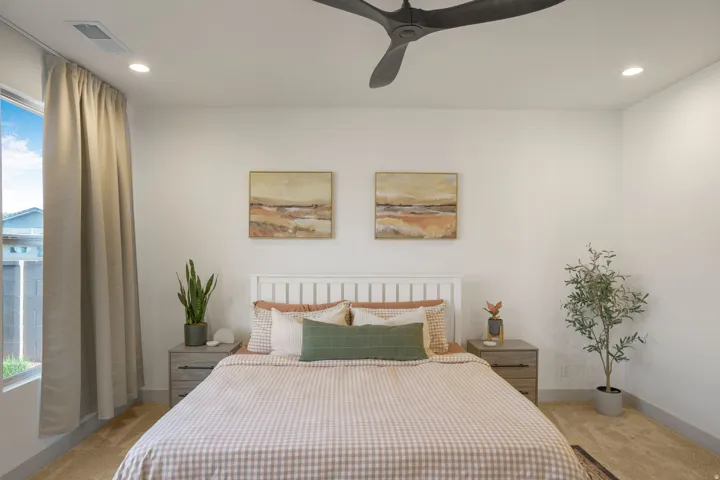 Bedroom featuring a white slatted headboard, recessed ceiling lighting, and a dark multi-blade ceiling fan