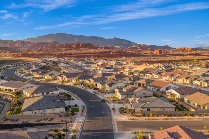 Curved street with homes featuring neutral-toned exteriors and dark tile roofing