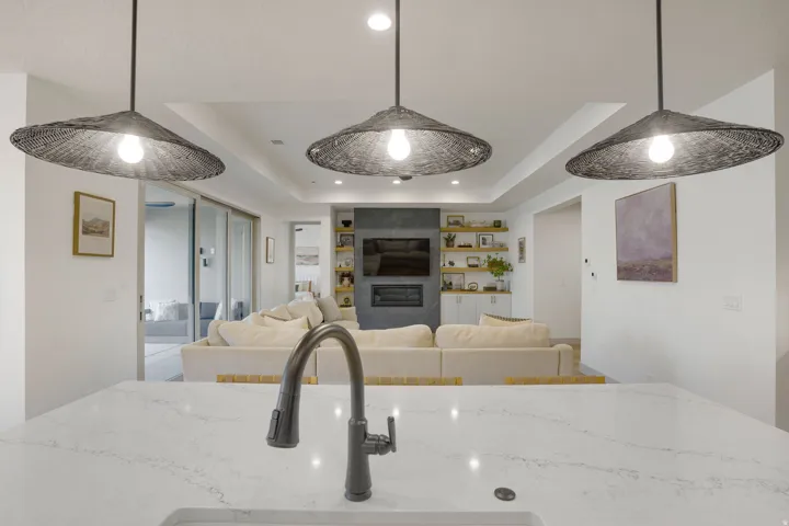 Expansive kitchen island featuring a light-toned countertop with a built-in sink and dark-finish faucet