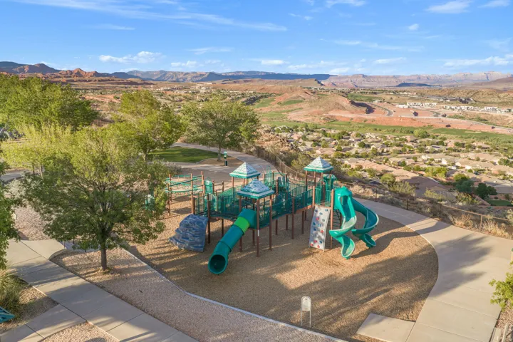 Outdoor playground featuring multiple slides, climbing structures, and a tunnel