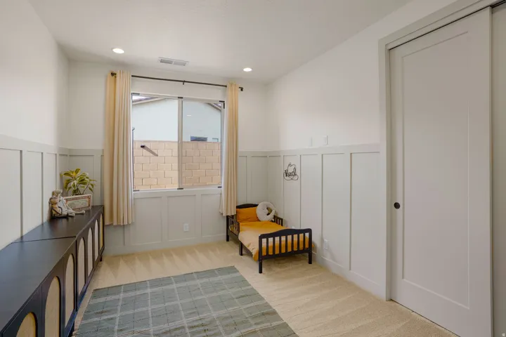 Recessed lighting illuminates a space featuring board and batten wainscoting