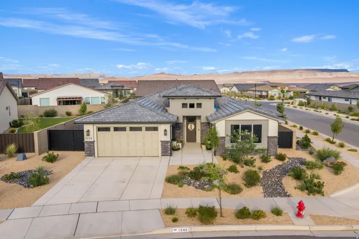 Contemporary stucco and stone exterior featuring a two-car garage