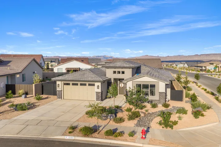 Contemporary desert architecture featuring a two-car garage, stone accents, and varied rooflines