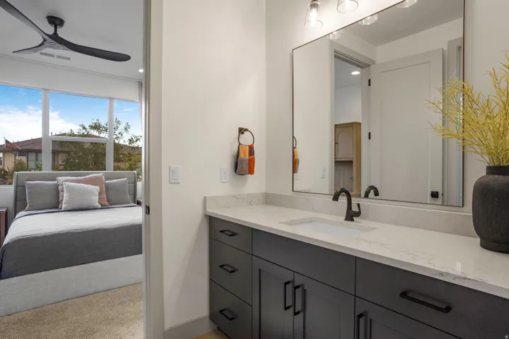 Modern bathroom vanity with a white countertop and dark cabinetry