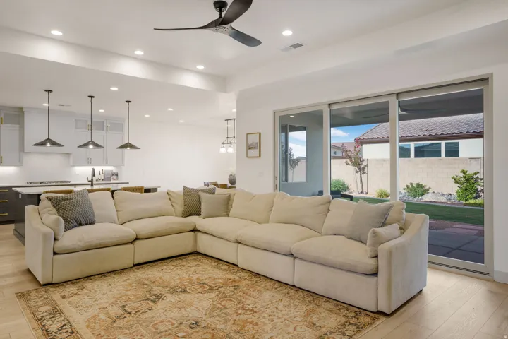 Open-concept living area with wood-finish flooring, recessed lighting, and a modern ceiling fan