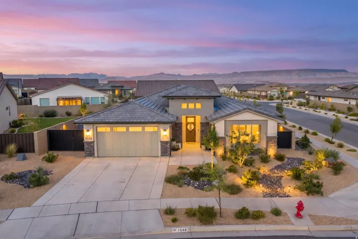 Contemporary stucco and stone-clad exterior with a tiled roof
