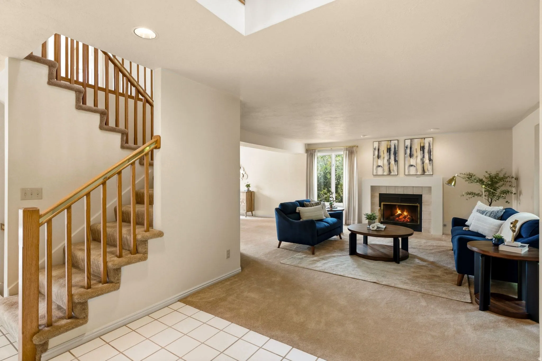 Carpeted staircase with wood railing, recessed lighting, and a fireplace with a mantel