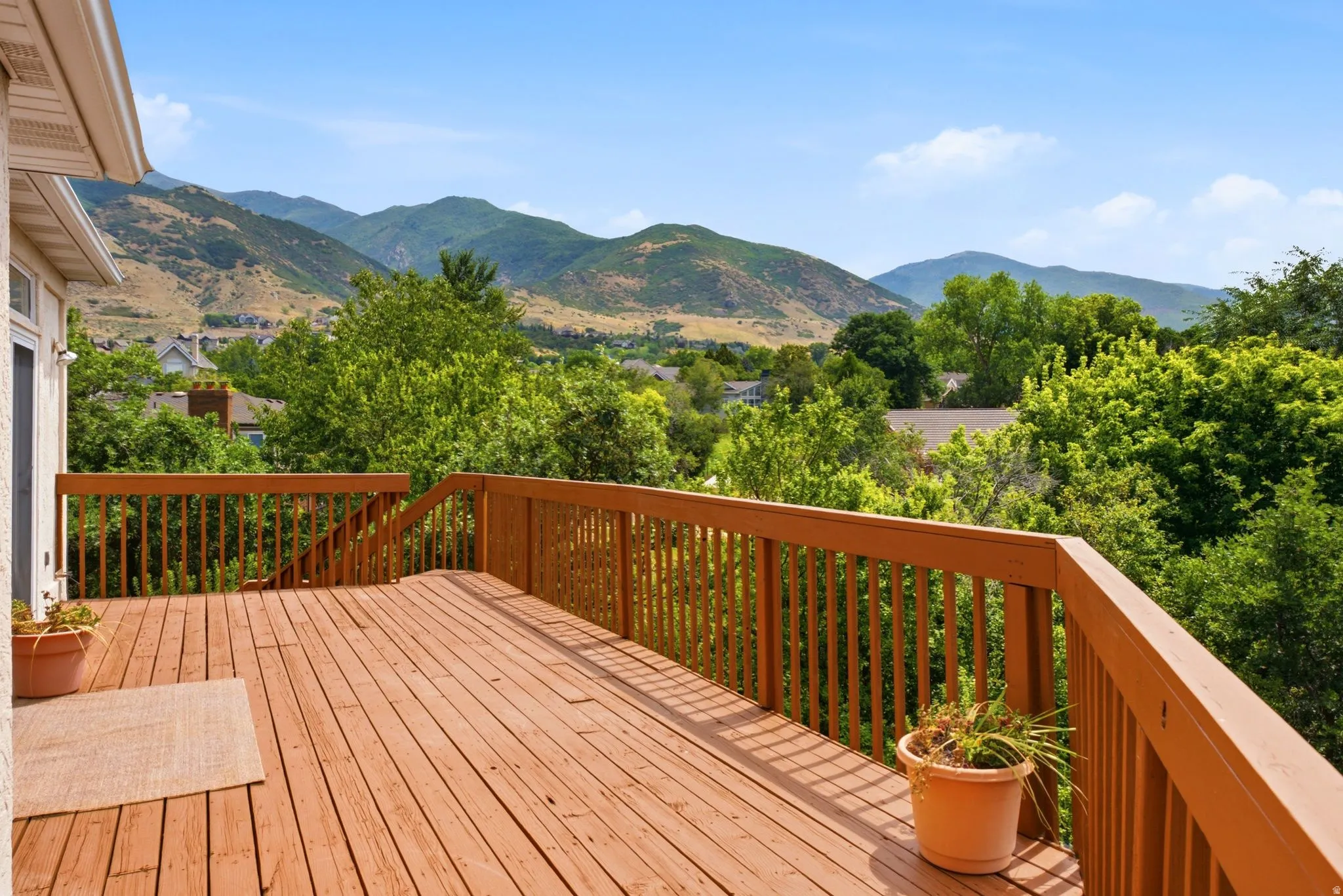 Spacious wood deck with wood railings overlooking mountain and tree scenery