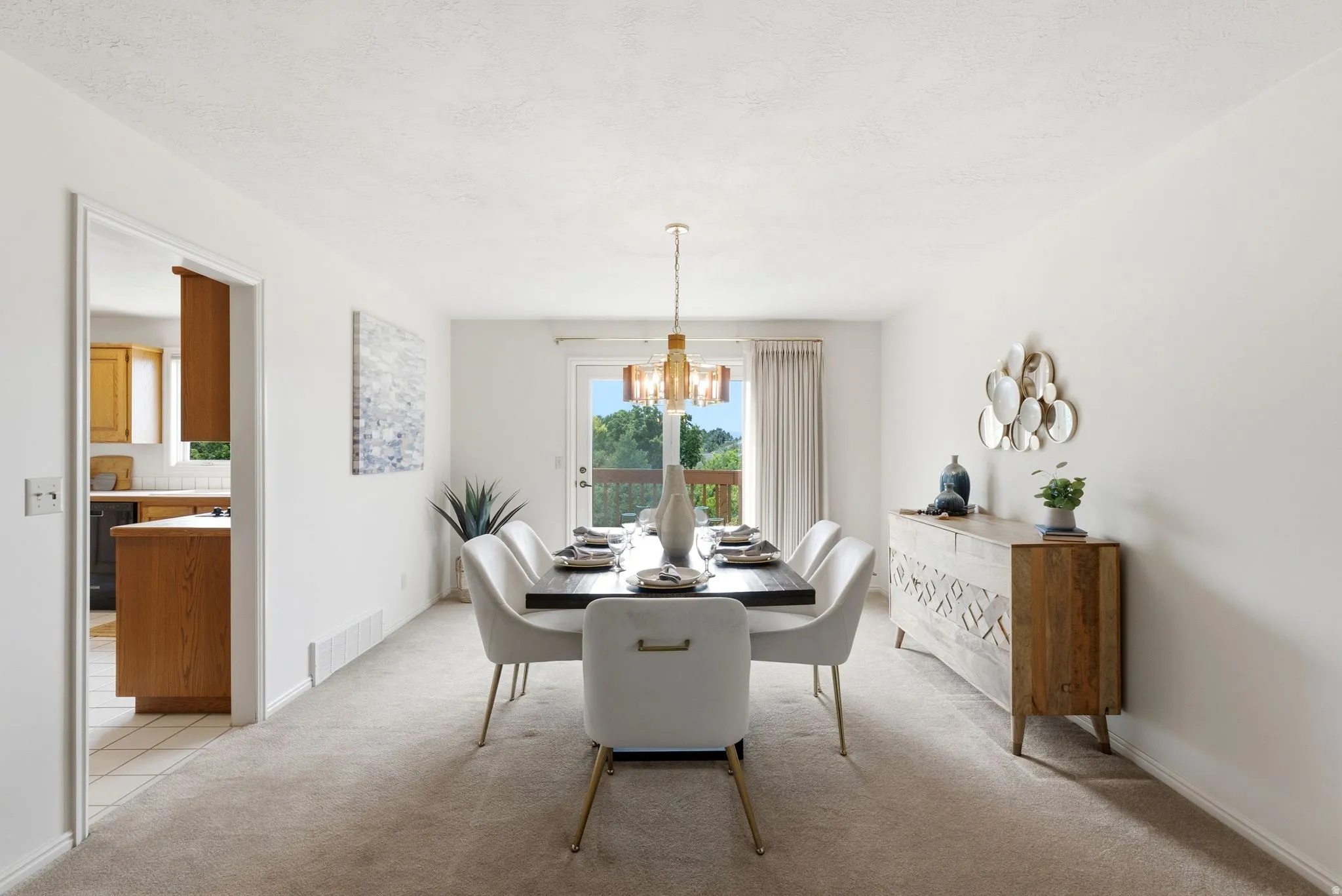 Dining area featuring a contemporary chandelier, neutral carpeting, and white walls