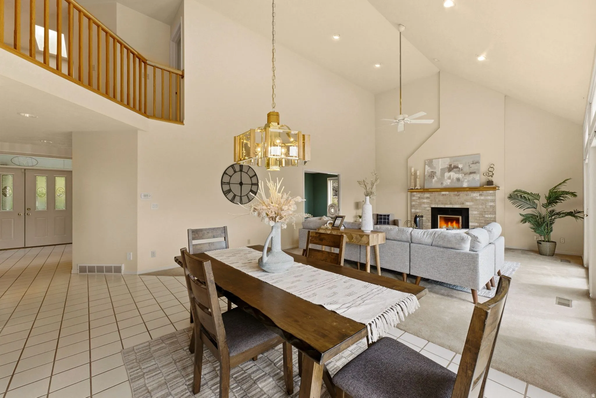 Vaulted ceilings with recessed lighting, a fireplace with a brick surround, and a wood mantel