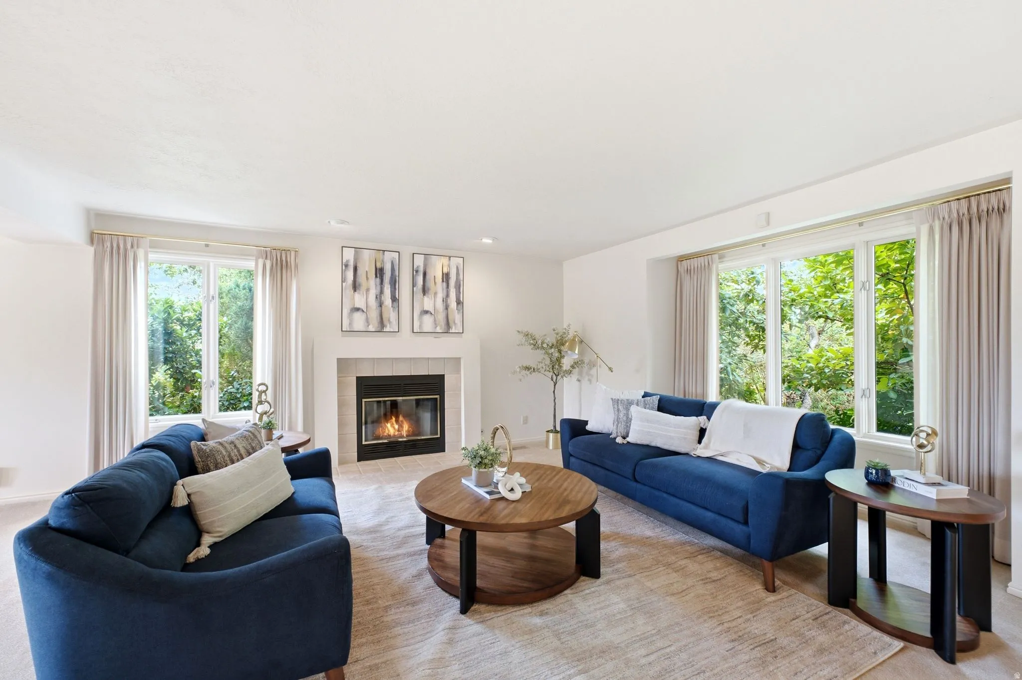 Bright living area with a central fireplace, multiple windows, and light-colored flooring