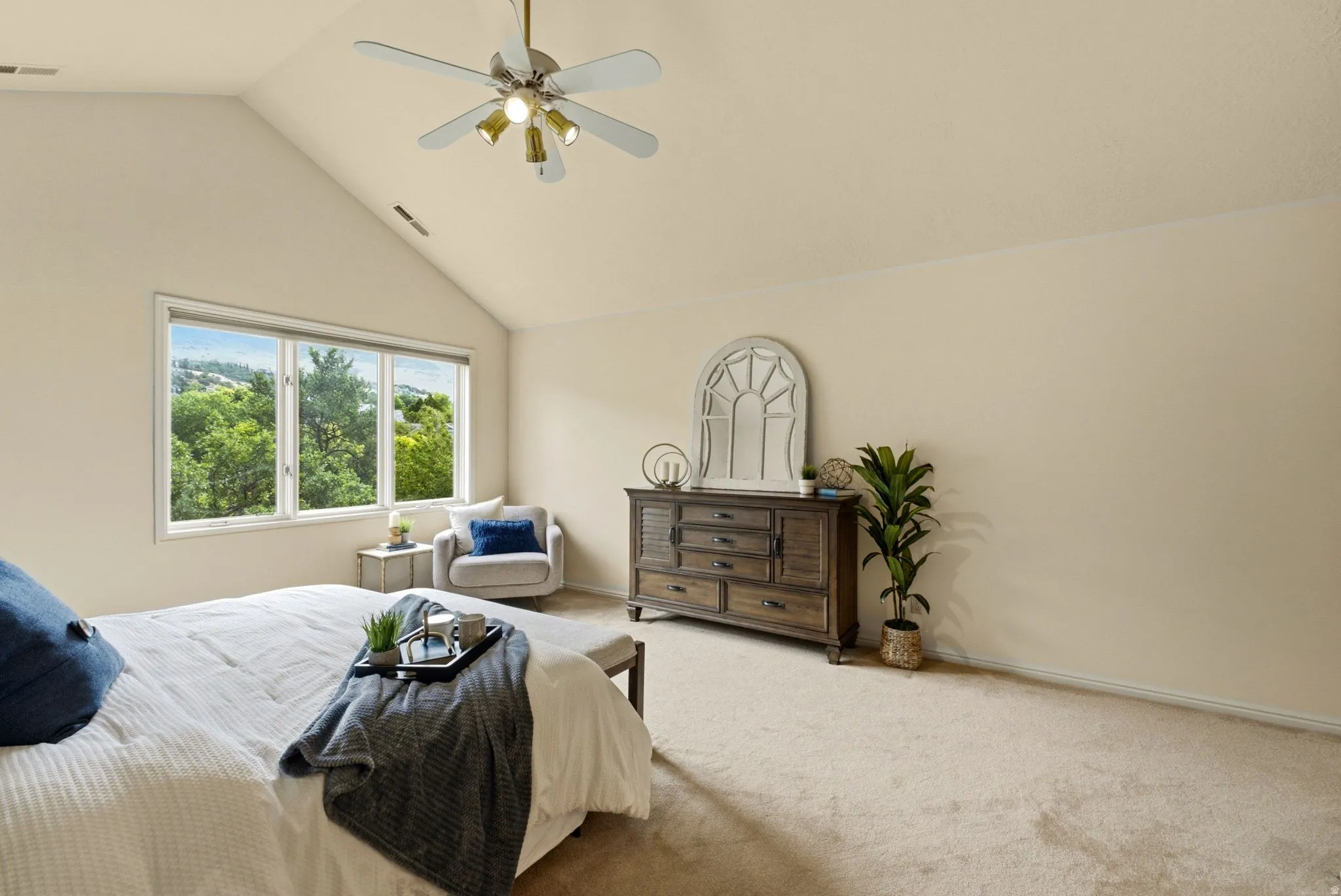 Vaulted ceiling with ceiling fan, large multi-pane window, and carpeted flooring