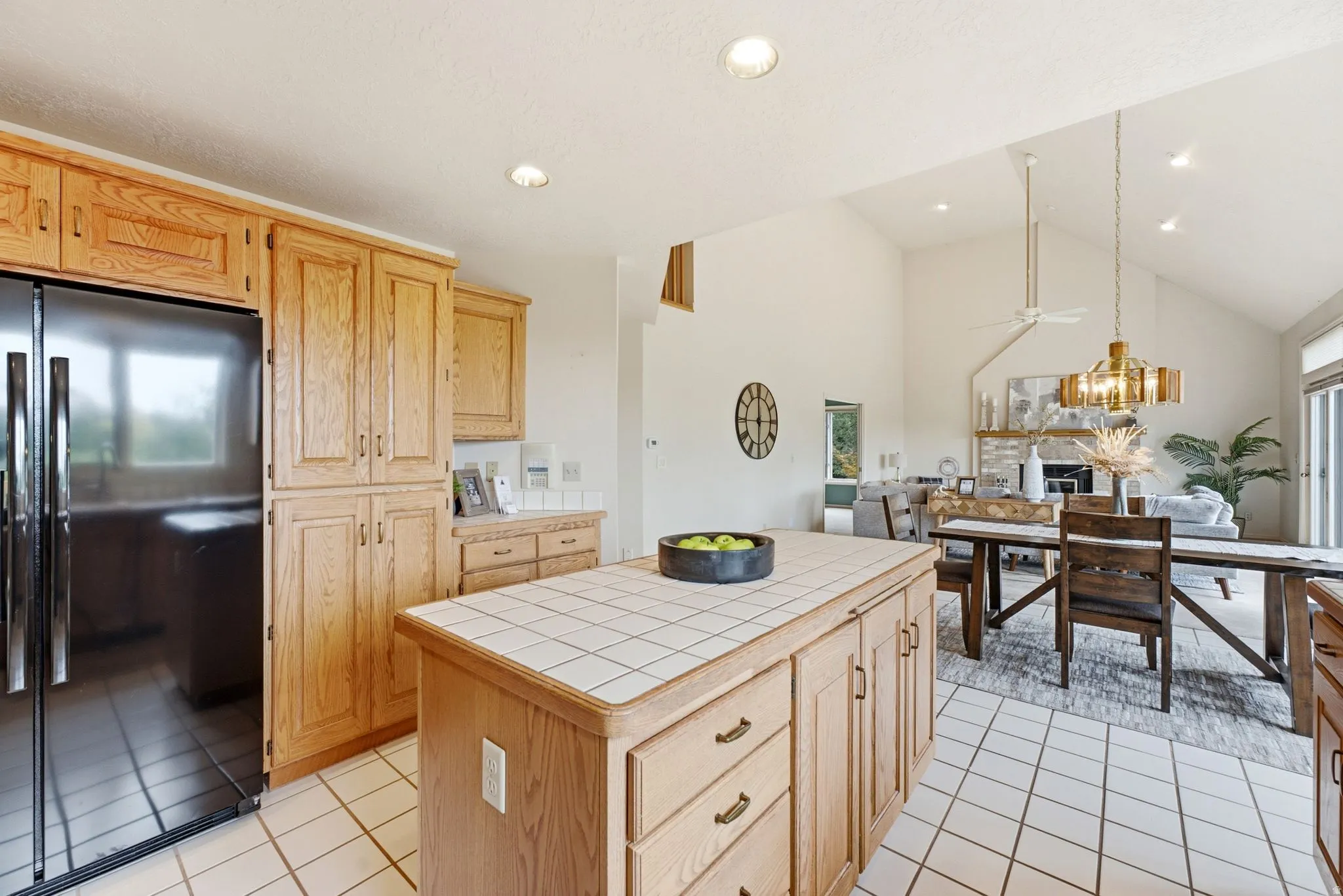 Kitchen featuring light wood cabinetry, tiled countertops, a center island with tiled surface, tile flooring, and recessed lighting