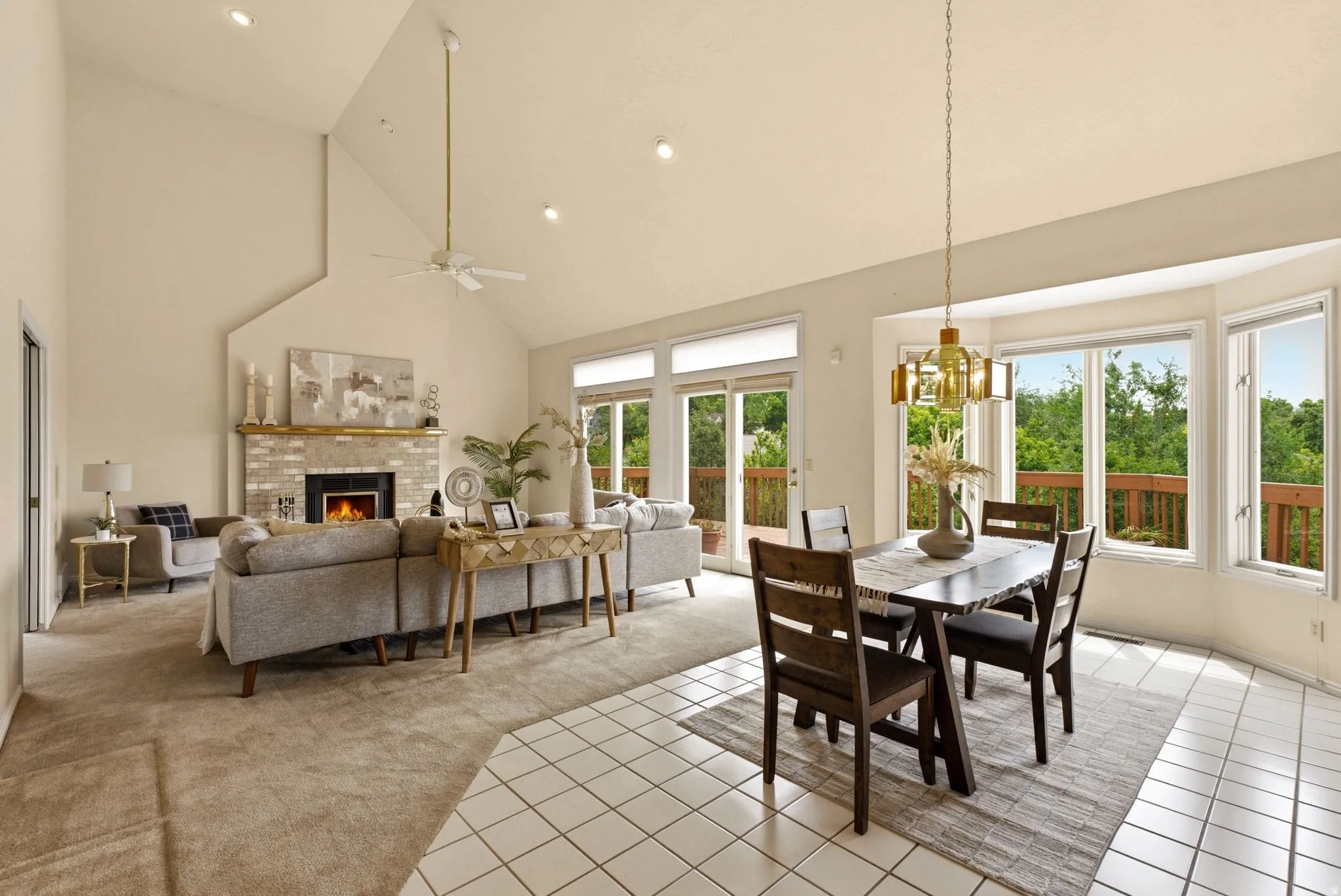 Vaulted ceilings, a stone-faced fireplace, and sliding glass doors to exterior decking define the living space