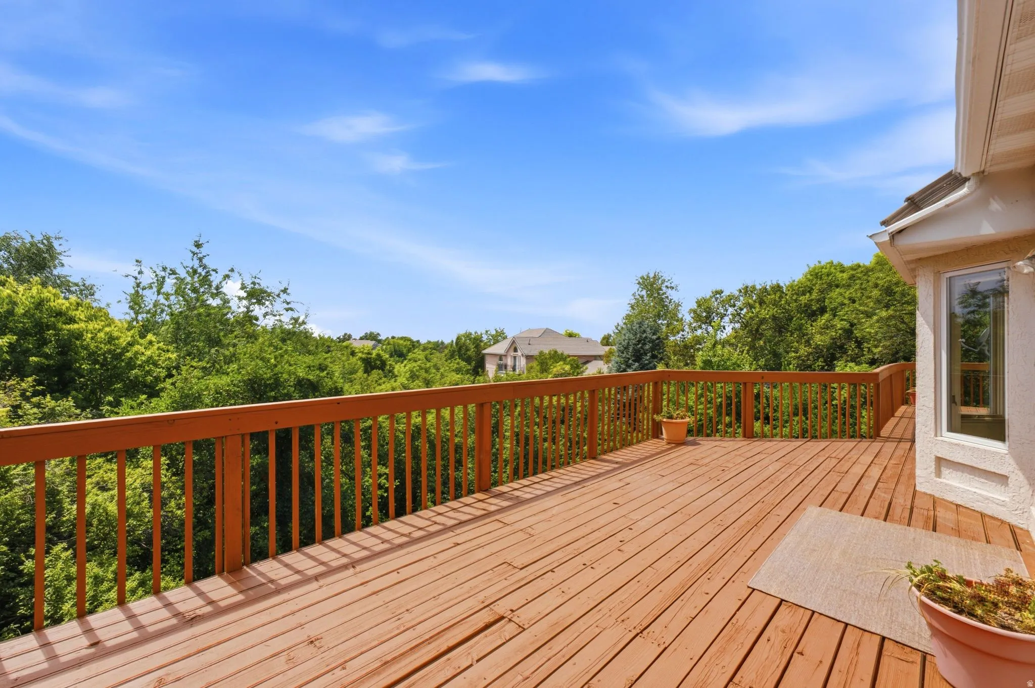 Expansive wood deck with natural wood railing, offering abundant outdoor living space