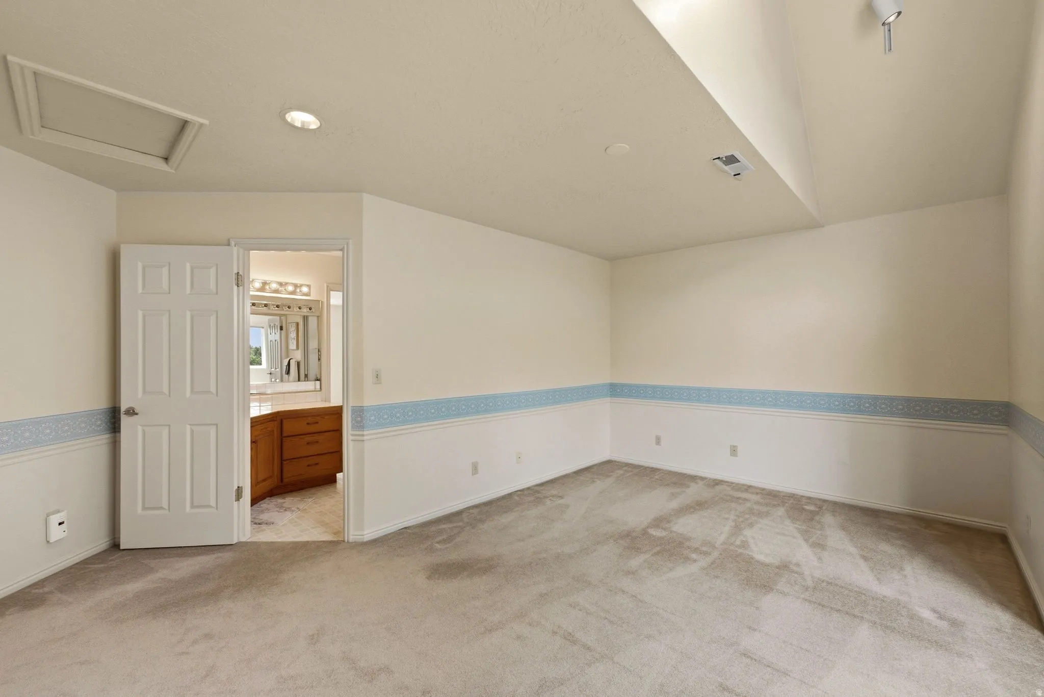 Wall-to-wall carpeting, recessed ceiling lighting, and overhead track lighting