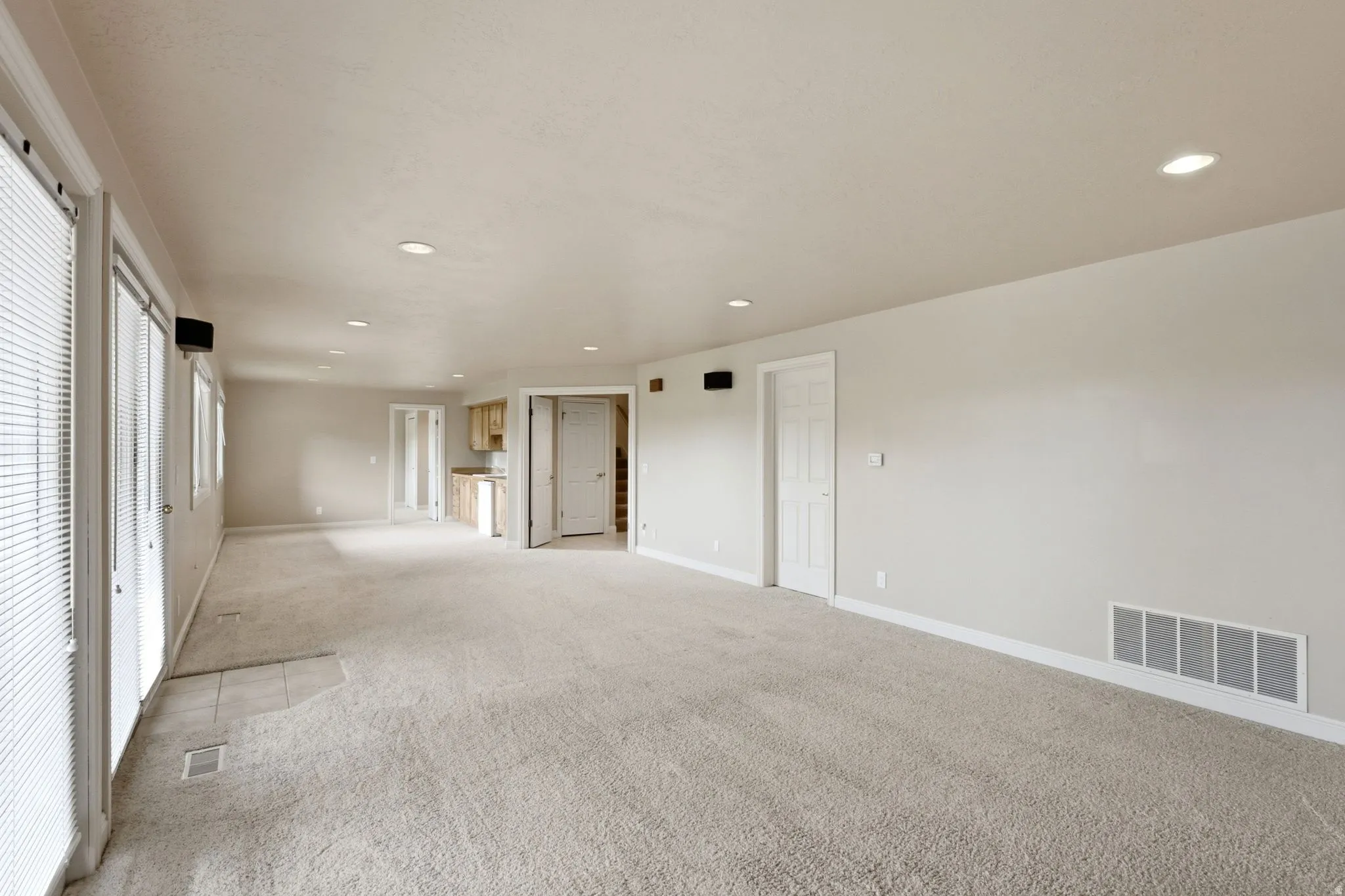 Spacious room featuring neutral carpet flooring and recessed lighting